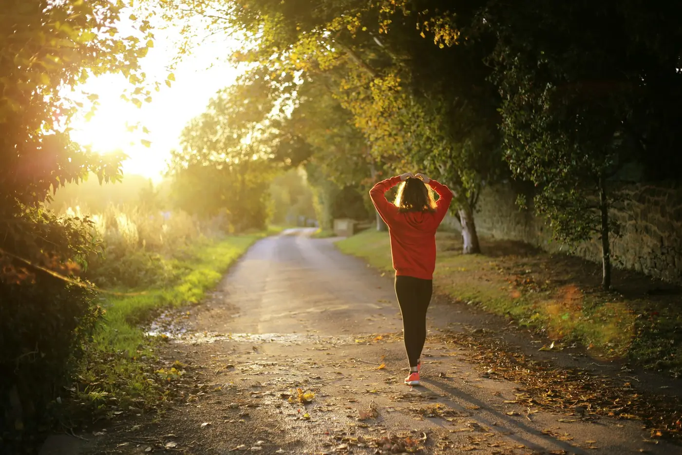 A woman walking along a country path in morning light